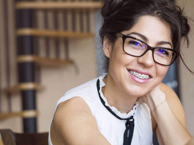 Woman happily wears braces.