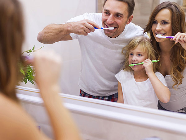 Family brushing teeth together